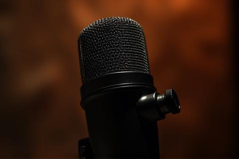 Primer plano de un micrófono de estudio, con un fondo desenfocado.